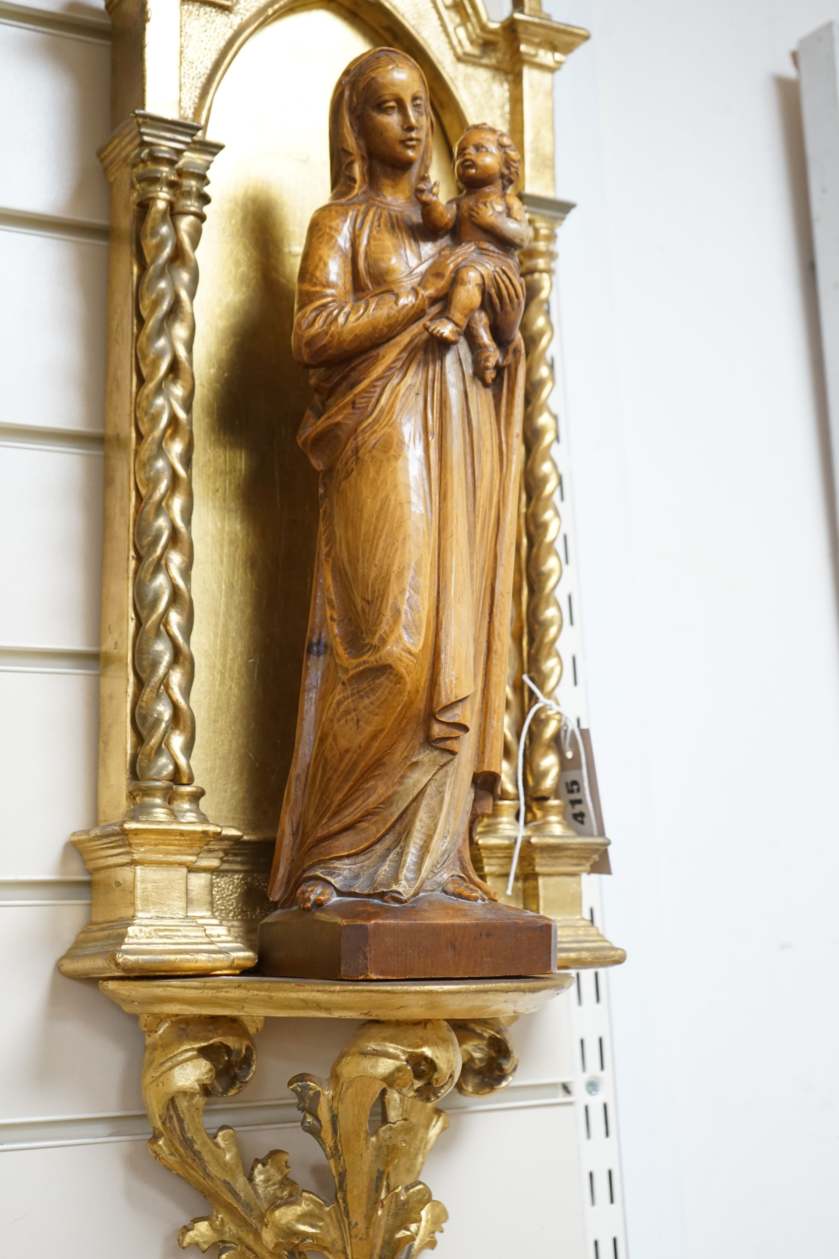 A 19th century architectural gilt niche and a 20th century carved pine group of Madonna and child 88cm